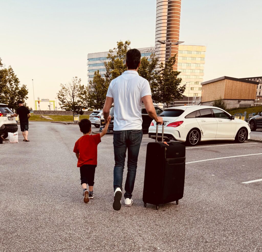 Child with his father carrying luggage