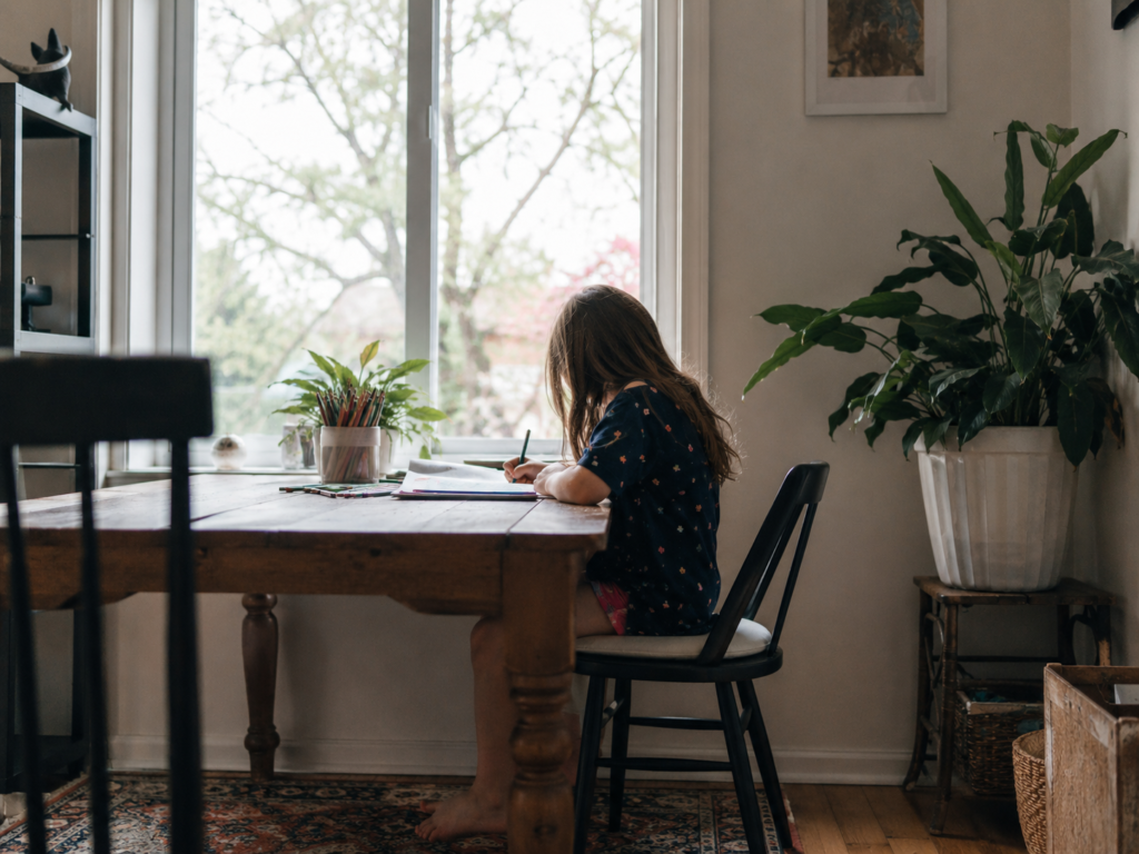 An only child drawing quietly at a table, reflecting independence and comfort with time spent alone.